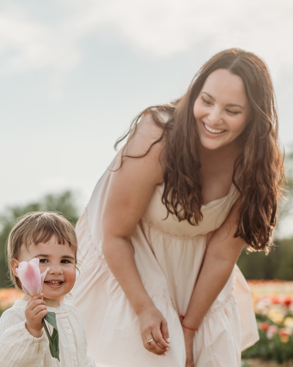 Annetta Fooks smiling beside her daughter in a tulip field